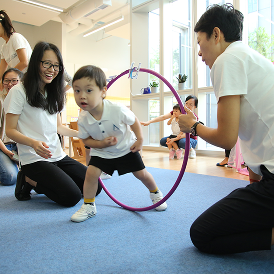 Kindergarten student in Avenues movement class going through a hoop
